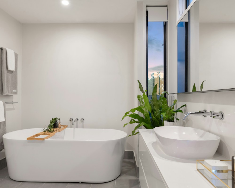 Minimalistische badkamer met lichte natuursteen en een vrijstaand bad.